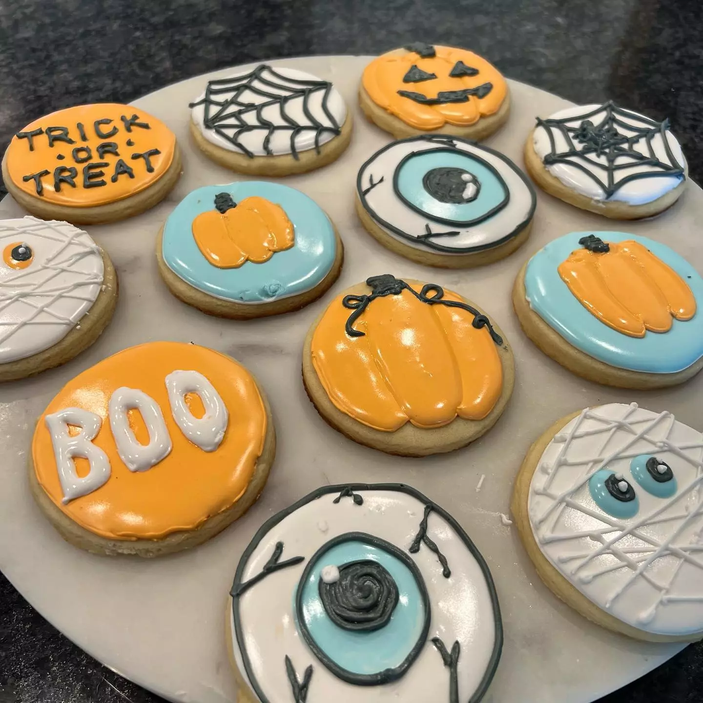 halloween themed cookies with pumpkins and cobwebs